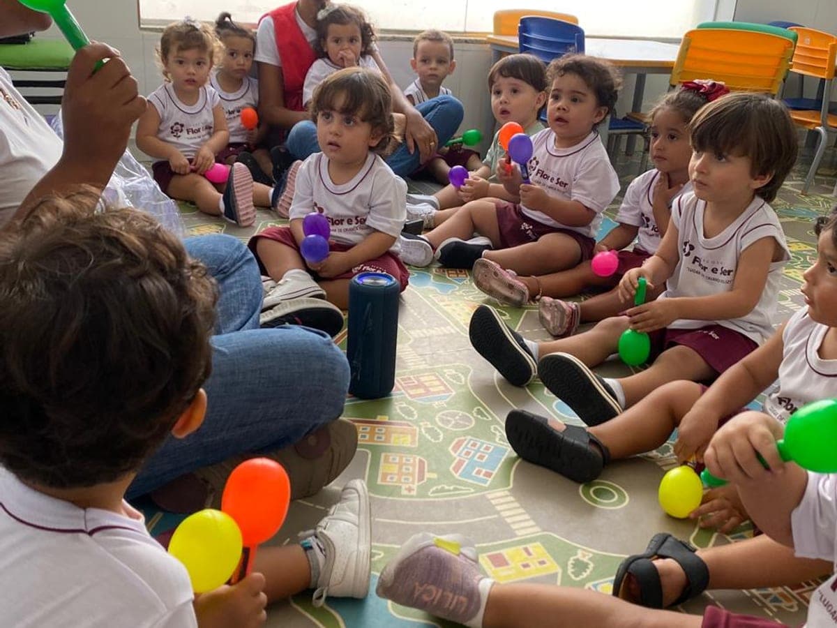 Turma do berçário em roda de música com chocalhos coloridos